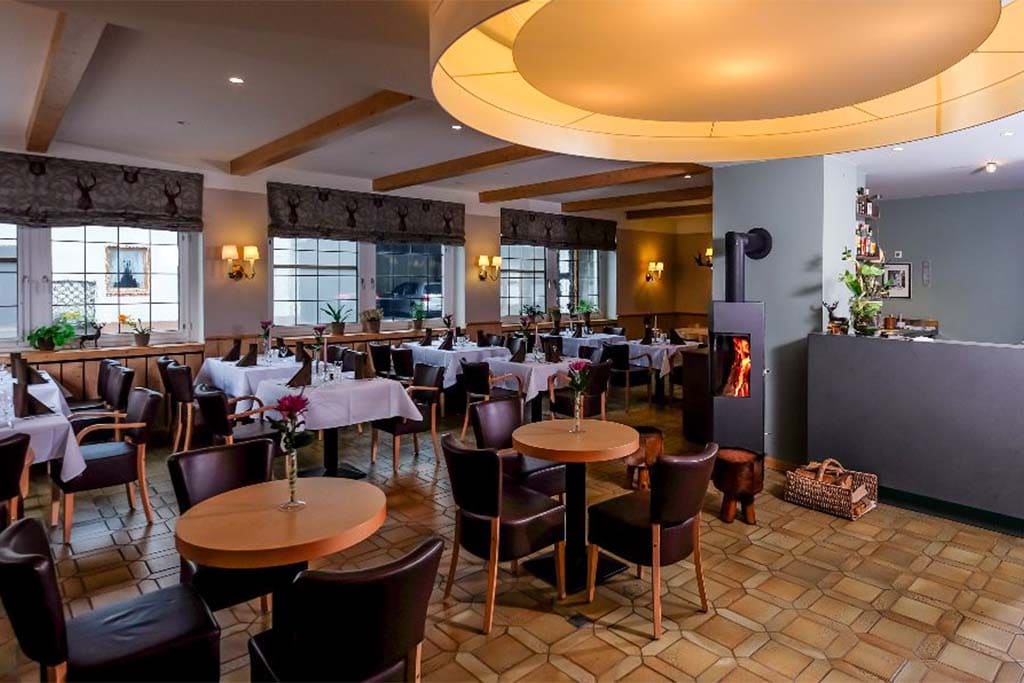 Gastraum des Restaurants mit eingedeckten Tischen und Theke