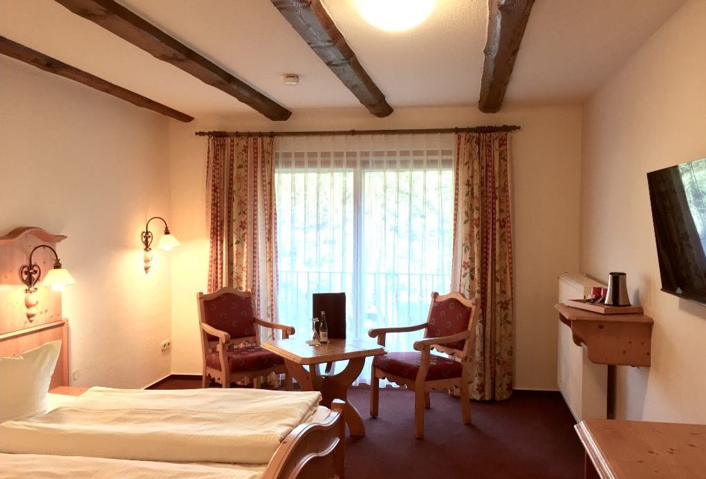 Doppelzimmer Superior mit Sitzgruppe, Fernseher und Balkontür