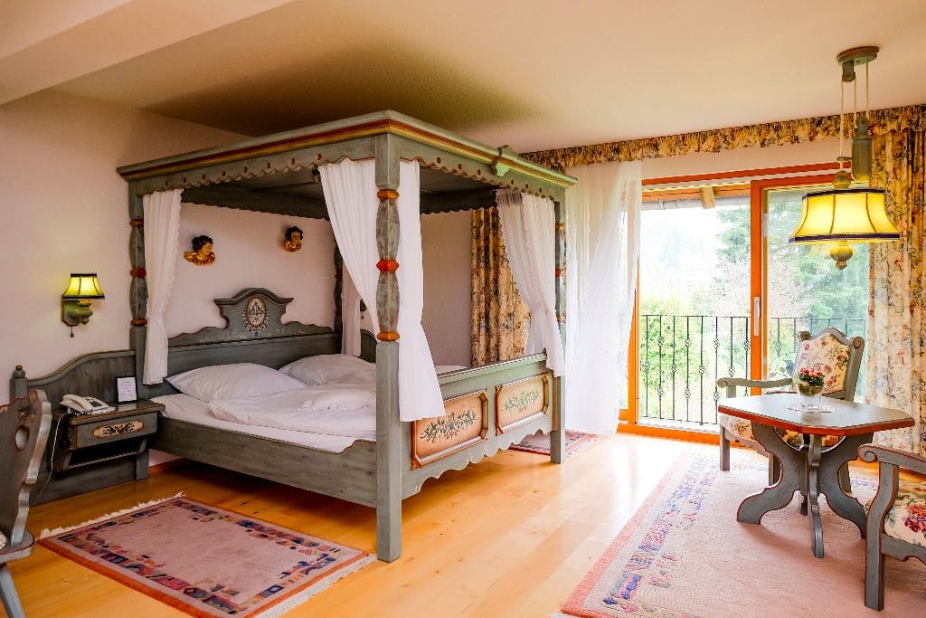Zimmer mit bemaltem Himmelbett und Zugang zum Balkon