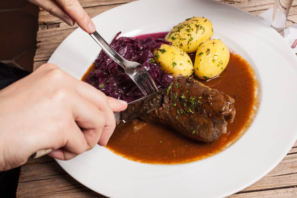Roulade vom Harzer Roten Höhenvieh mit Rotkohl und Kartoffeln auf weißem Teller