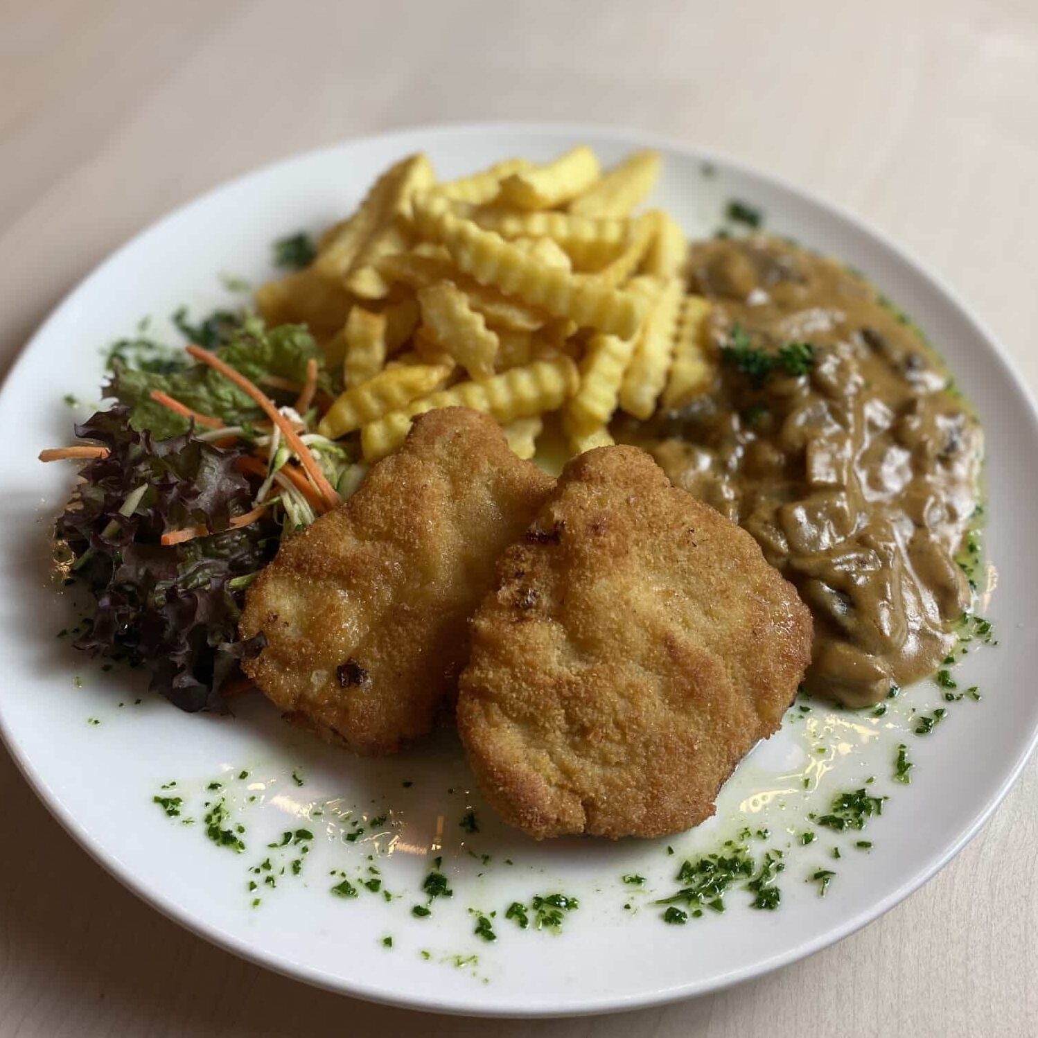 Paniertes Schnitzel mit Beilage auf einem Teller im Restaurant Harzer Hof