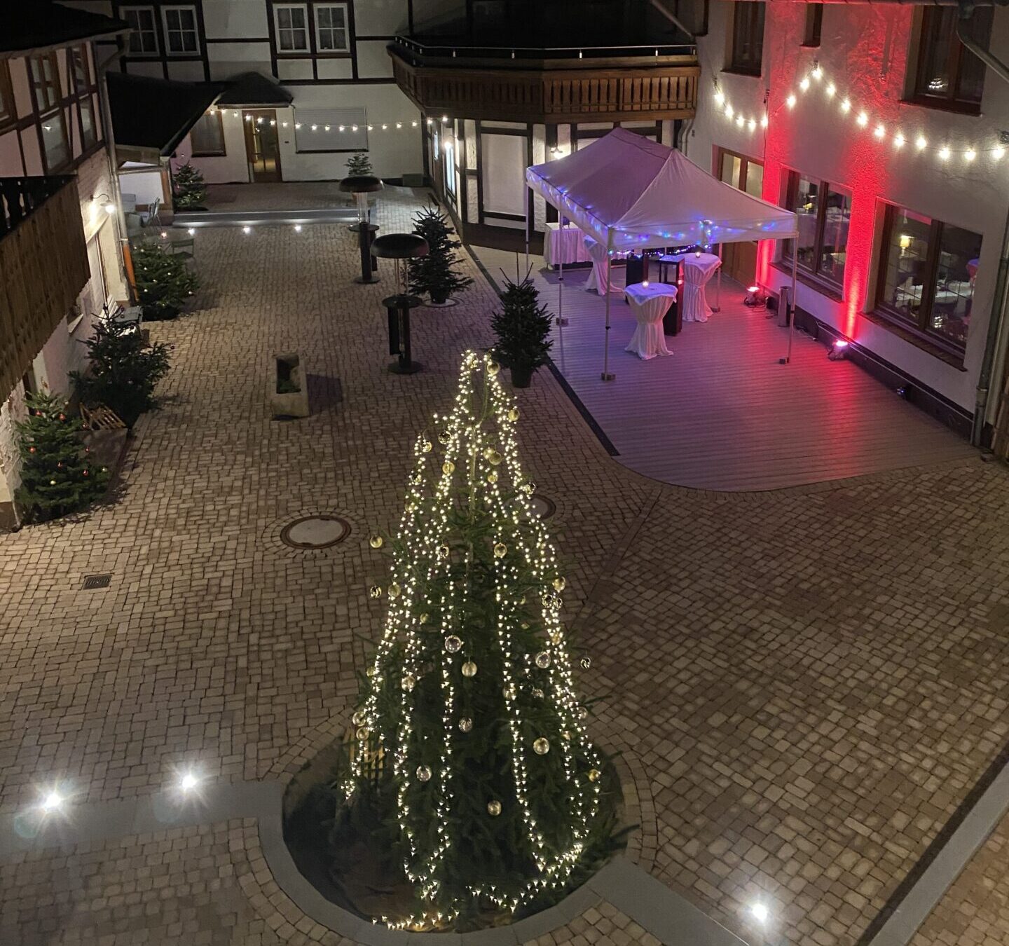 Beleuchteter Weihnachtsbaum im Innenhof des Harzer Hofs am Abend